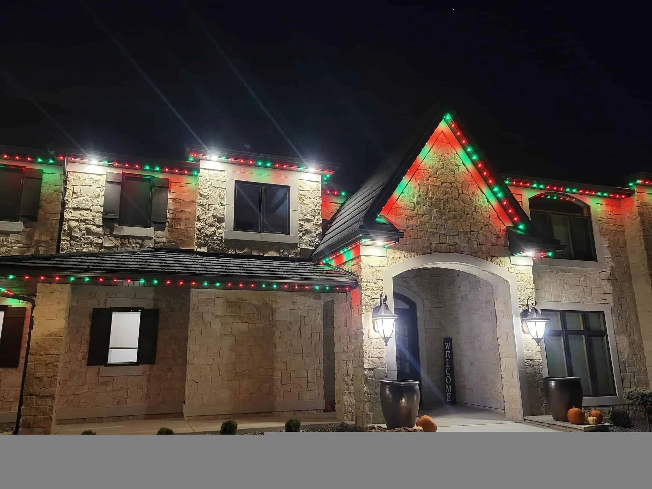Stone entry and gables in red and green roofline lighting